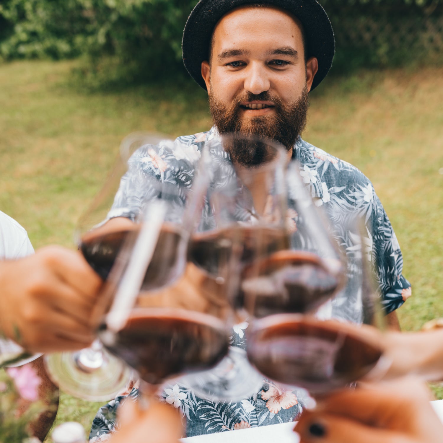 Ein Mann der mit Rotwein mit vier Freunden anstößt