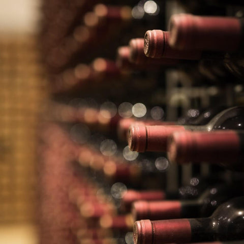 Rotweinflaschen liegend gelagert in einem Weinregal